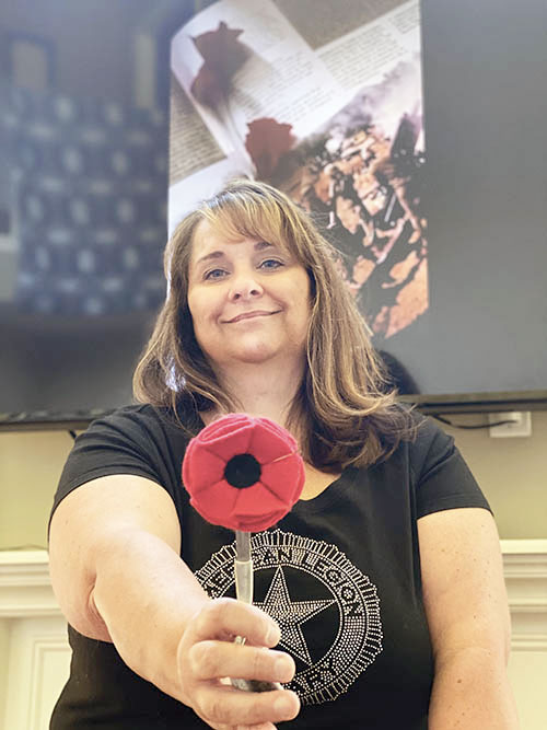 ALA member Jenny Tracy of Indiana extends a cloth poppy.