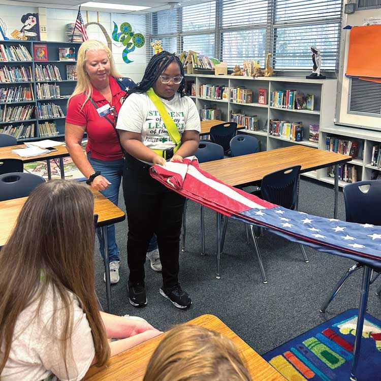 unit member helps youth fold the flag