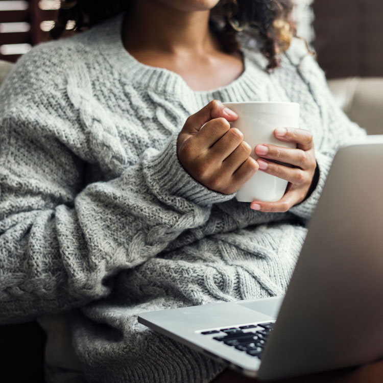 woman having coffee with computer on lap